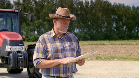 Farmer checking some data from the clipboard on the farm Video stock 94861884