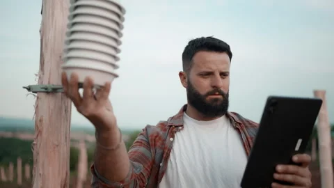 Farmer Checking Weather Sensor in Vineyard Using Digital Tablet Stock Footage 327266496