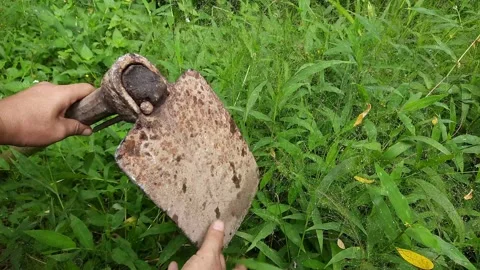 A farmer checks the durability of a rusty hoe Stock-Footage 296339519