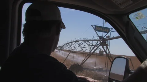 A farmer checks irrigation operation from inside pickup truck. Stock Footage 88745851