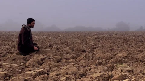 Farmer checks on poor soil. Long shot Stock Footage 42251156