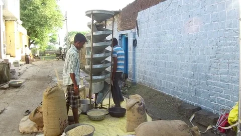 Farmer cleaning grains help of machine in rural village Stock Footage 77654141