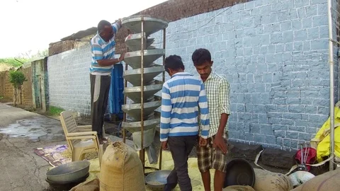 Farmer cleaning grains help of machine in rural village Stock Footage 77654230