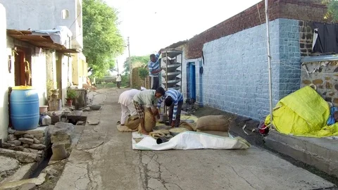 Farmer cleaning grains help of machine in rural village Stock Footage 77654333