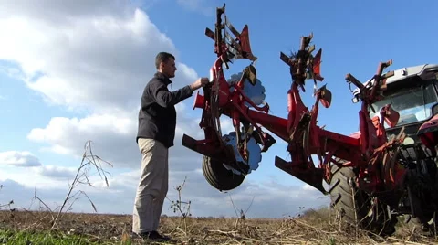 Farmer cleaning the plow after plowing Stock Footage 48362082