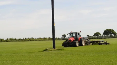 Farmer cutting high quality grass in preperation for lawn turf yorkshire uk Stock Footage 76209738