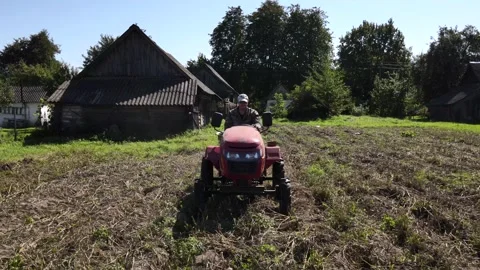 Farmer digs potatoes with a small tractor Stockbeeldmateriaal 222058292