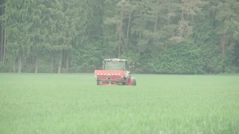 Farmer distributing fertilizer on field in slowmotion Vídeo Stock 134601772