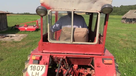 Farmer drive an old red tractor through meadow Stock Footage 47980153