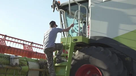 The farmer driver goes inside the combine harvester Vidéo 139650030