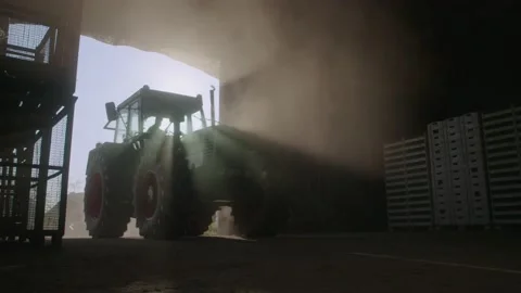 Farmer drives her tractor into the shed at the  end of working day Stock Footage