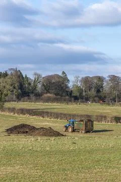 Farmer drives tractor through open field 库存照片