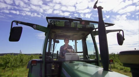 Farmer driving her tractor with son on board Video stock 63023210