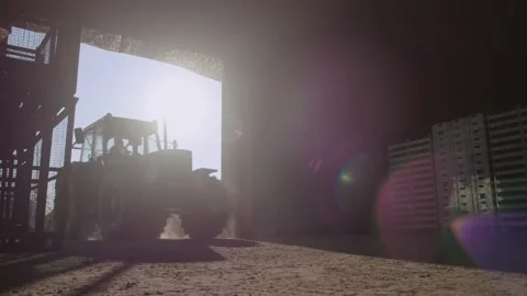 Farmer is  driving his tractor backwards out of the barn Stock Footage 152171534