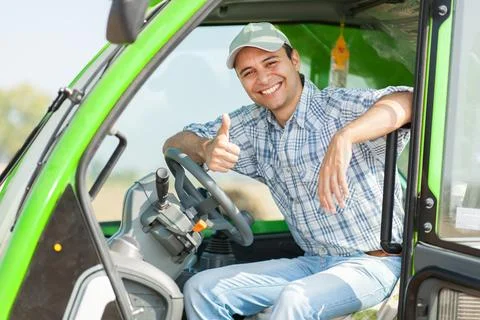 Farmer driving tractor in corn field Stock Photos