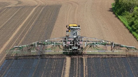 Farmer driving tractor distributing liquid manure fertilizer for crop Stock Footage 340553438