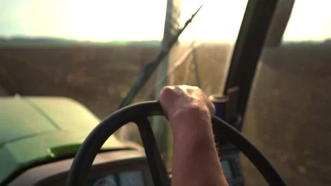 Farmer driving a tractor in the field. view from the cab. sunlight. steering Stock Footage 260406878