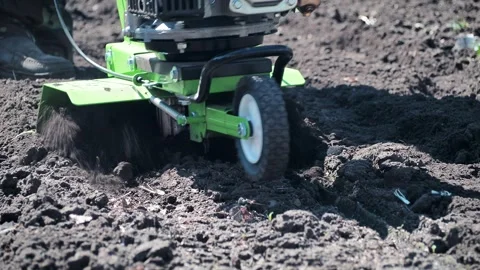 The farmer is engaged in loosening the soil using a motor cultivator. 스톡 동영상 241066176