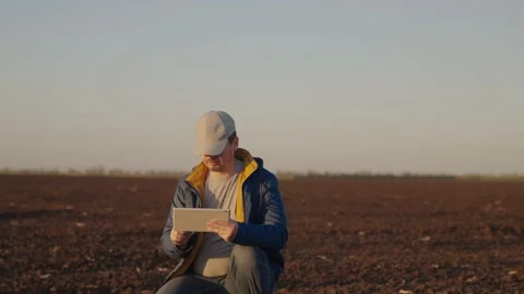 Farmer enters data for report on soil condition into tablet. Agricultural Video stock 232544681