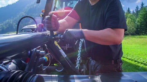 Farmer is fixing something on the grass cutting machinery Stock Footage 85551817