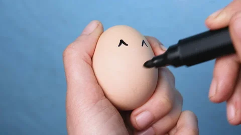 Farmer hand drawing smiley face on egg. Creative Easter concept. Cultural symbol Stock Footage 188212477