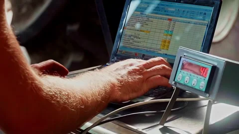 Farmer hands typing data on laptop near digital scale in the farm Stock Footage 332446250
