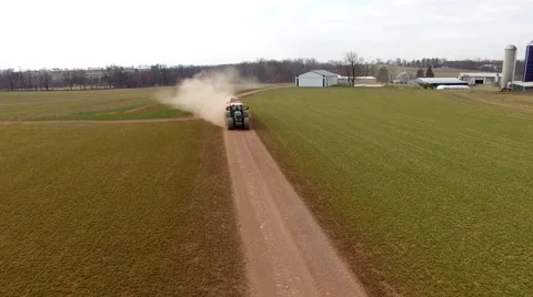 Farmer Hard at Work Hauling with Tractor Down Dirt Dust Lane Aerial Stock-Footage 61175763