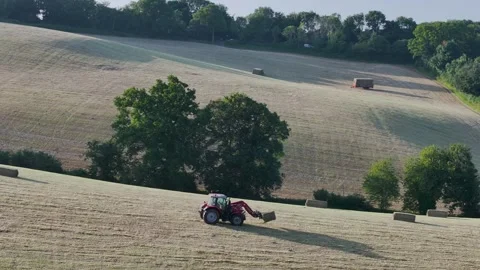Farmer harvests hay with a tractor in the fields of Devon, Torquay, England Stock-Footage 311706424