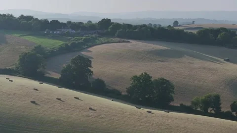 Farmer harvests hay with a tractor in the fields of Devon, Torquay, England Stockbeeldmateriaal 311706567