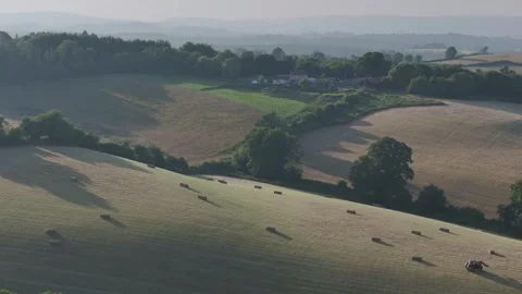 Farmer harvests hay with a tractor in the fields of Devon, Torquay, England Stockbeeldmateriaal 311706569