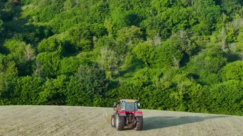 Farmer harvests hay with a tractor in the fields of Devon, Torquay, England Stockbeeldmateriaal 311706999