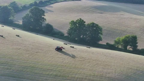 Farmer harvests hay with a tractor in the fields of Devon, Torquay, England Stockbeeldmateriaal 311707004