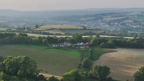 Farmer harvests hay with a tractor in the fields of Devon, Torquay, England Видео 311782345