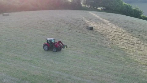 Farmer harvests hay with a tractor in the fields of Devon, Torquay, England Видео 311782465