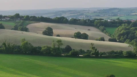 Farmer harvests hay with a tractor in the fields of Devon, Torquay, England Видео 311782485