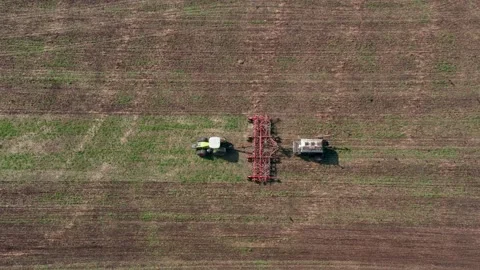 The farmer has begun spring field work to close the moisture and harrowing Stock Footage 154369599
