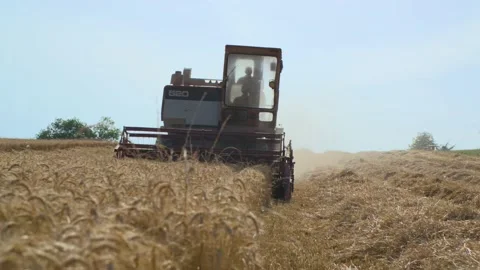 A farmer in his tractor harvests a field of wheat, in France Stock Footage 208055910