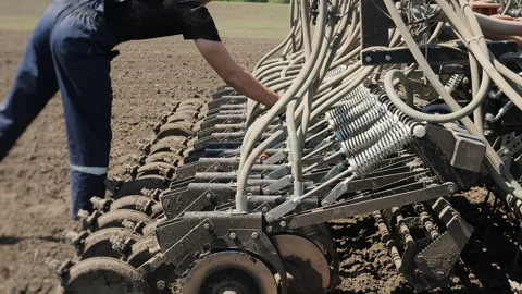 Farmer Inspecting Seeder Mechanism During Field Planting Operation Stock Footage 345022111