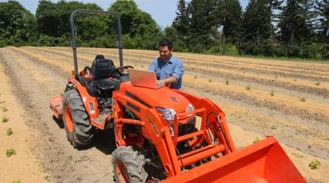 Farmer with laptop computer by tractor Stock Footage 47497564