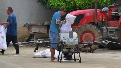 Farmer Loading Fertilizer into Agricultural Drone in Rural China Stock Footage 340050460