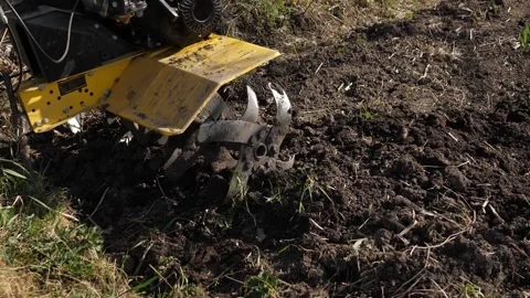 The farmer loosens the ground using a small tractor. Stock Footage 130397230
