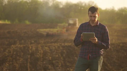 Farmer man read or analysis a report in tablet computer on a agriculture field Video stock 90085497