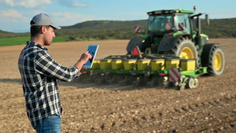 Farmer man read or analysis a report in tablet computer on agriculture field Video stock 195056728