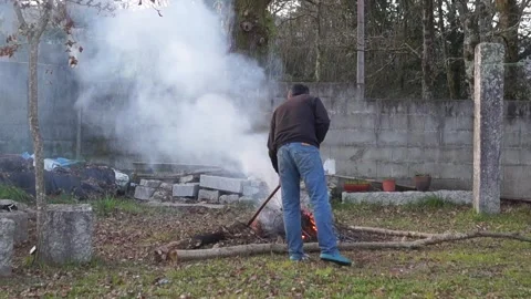 Farmer Managing Backyard Fire for Garden Waste Stock Footage 330015528