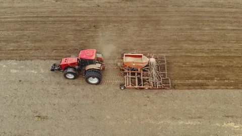 Farmer on a modern tractor performs processing of dusty soil with a Vídeo Stock 128364402