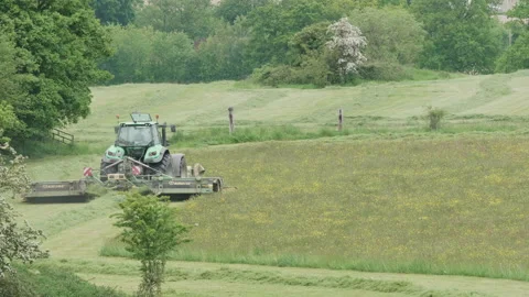 Farmer mowing a field for hay using agricultural machinery 02. 4K locked tripod Video stock 154910490