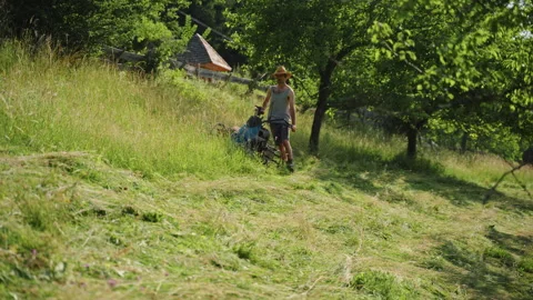 Farmer mows grass on small alpine farm with hard work and dedication 스톡 동영상 344149037