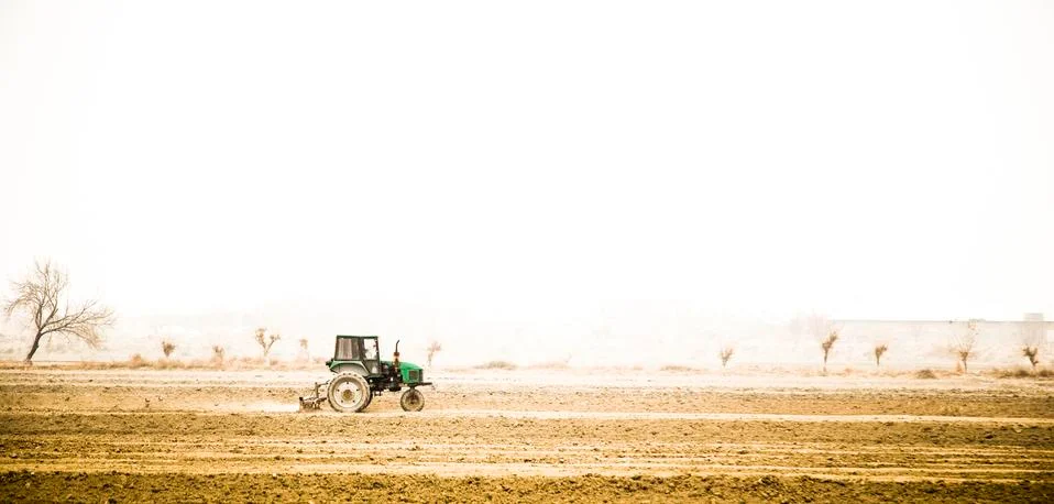 Farmer in old tractor preparing land with seedbed cultivator. Stock Photos
