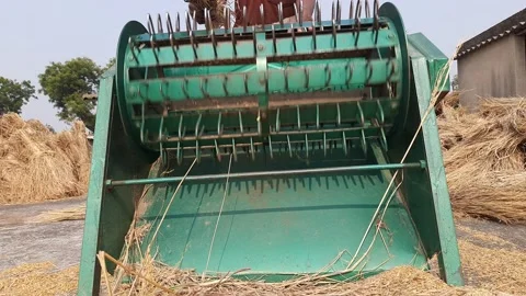 A farmer operates a paddy threshing machine. Stock Footage 224035501