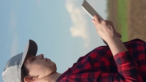 Farmer in plowed field works with computer, Business Farm. Farmer woman with Stock Footage 265018048